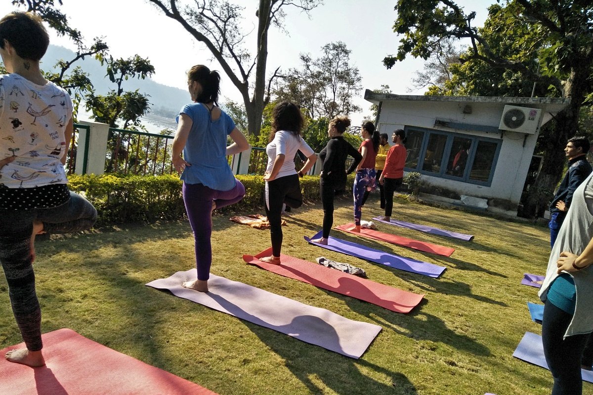 Complete beginner receiving hands-on guidance during yoga practice in Rishikesh