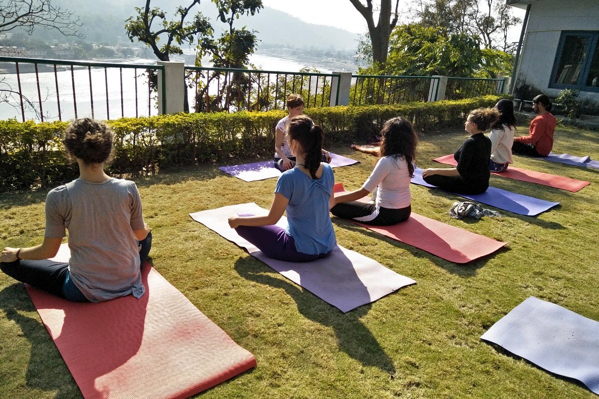 Guided meditation class in a garden with views of the Ganga