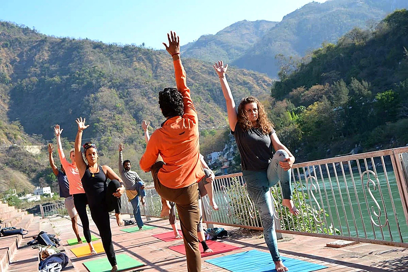 Students holding a steady standing balance pose on the ashram terrace