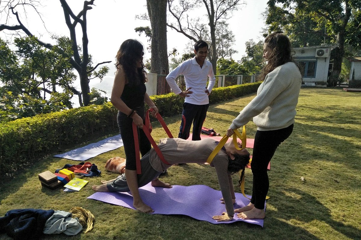 Yoga alignment adjustment with straps during TTC anatomy practice